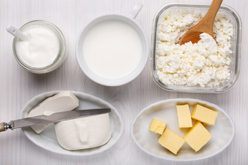 Different type of dairy products on white wooden background.