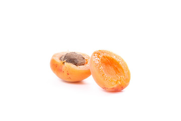 Several of harvested apricots whole and halved on white background..