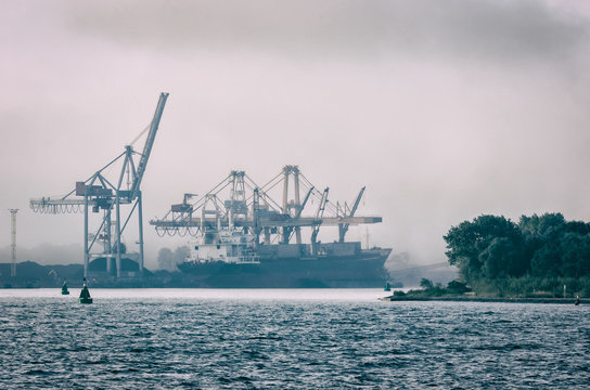 SHIP IN A SEA PORT - Transshipment terminal in the mist
