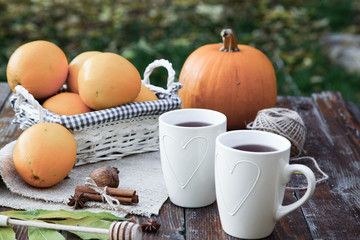 tea with lemon, honey, oranges, autumn leaves on woodenbackground