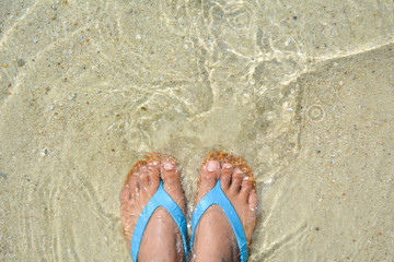 Fototapeta na wymiar Top view feet women and sandal on the beach