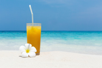 Cocktails in glass on white sandy beach