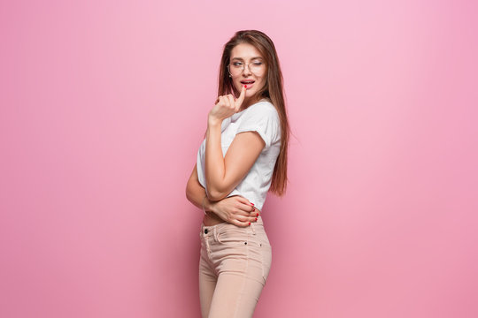 Pretty young sexy fashion sensual woman posing on pink background dressed in hipster style jeans