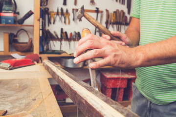 Male carpenter working on raw wood / boards / plank.