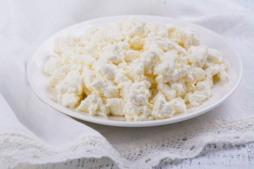 Homemade cottage cheese on white plate. Rustic style