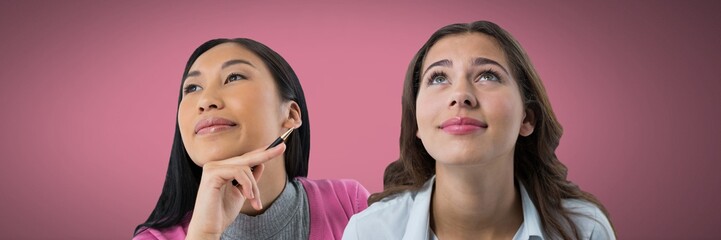 Two women looking up with pink background