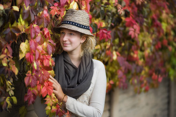 Portrait of a beautiful young girl against the background of autumn leaves
