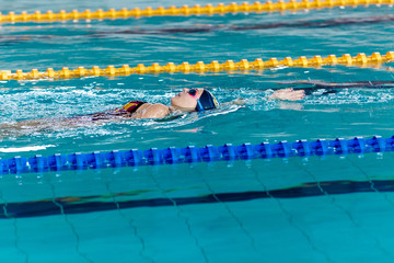 woman swimming with swimming hat in swimming pool