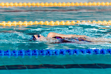 woman swimming with swimming hat in swimming pool