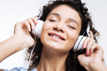 Happy woman closing eyes while listening to music