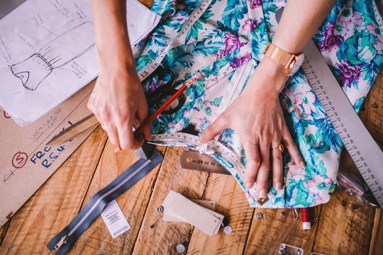 Close-up of female designer measuring textiles