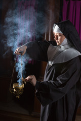 Nun preparing incense for mass