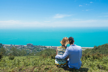 Fototapeta na wymiar Young couple in love looking at sea from top of mountain.
