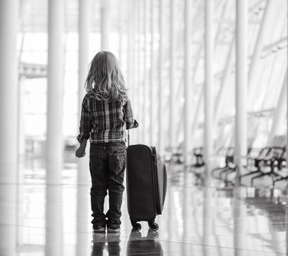 Little Kid With Luggage  In Airport Terminal. Back View.  Happy Travel Concept. Child With Bag Ready For Holiday. Vacation In Portugal.  