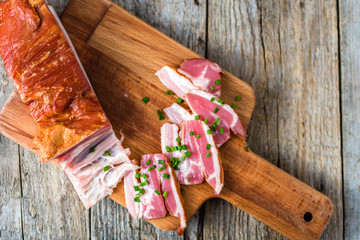 Smoked bacon on wooden table, pork meat..