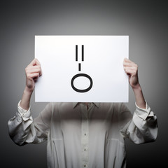 Woman is holding white paper with smile. Surprise concept.