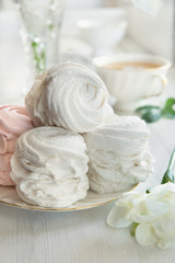 Fototapeta na wymiar Soft vanilla meringue dessert with white flowers, wooden background