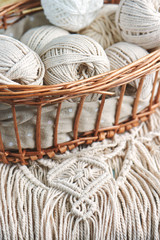 Obraz premium Handmade macrame braiding, background thread on a wooden Board top view