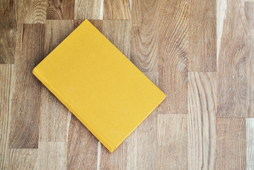 Yellow book on the wooden scratched table