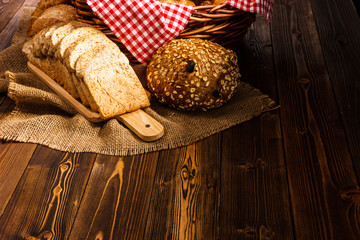 Bakery Assortment on wooden table on dark background. Still Life of variety of bread with natural morning light..