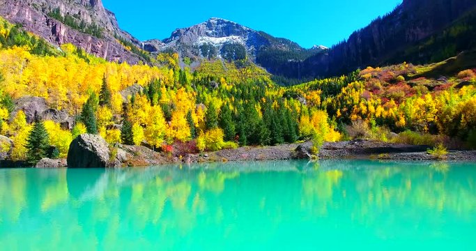 Bright Turquoise Blue Lake With Yellow Fall Foliage And Mountain Peak In Background - Telluride, Colorado, USA