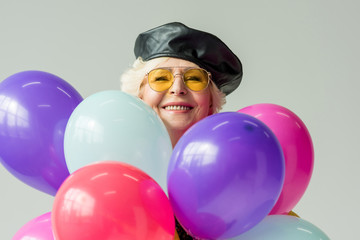 senior woman with colorful balloons
