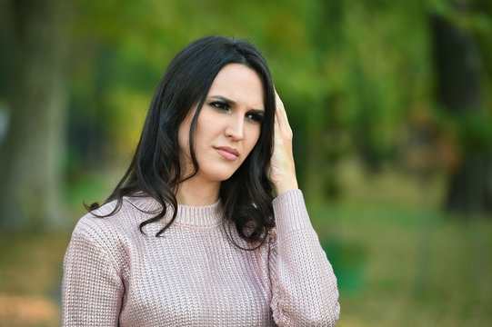woman headache in a park in autumn