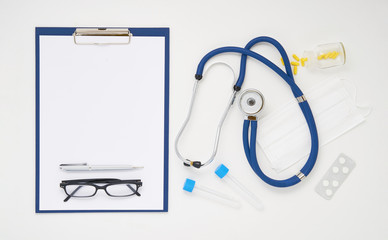 Doctor table with medicines, stethoscope and glasses, top view