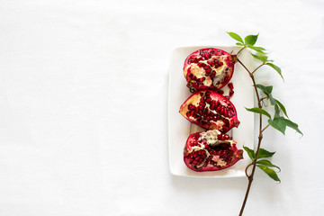 Top view on work table pomegranate. Tablet, wild grape branch and . Flat lay