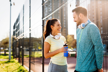 Handsome man and attractive woman talking on court