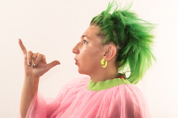 A girl with green hair in a pink cape rehearses gestures for a pantomime performance. She is going...