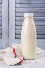 Fototapeta na wymiar Fresh organic cow milk in a plastic bottle on wooden table. Rustic stule. Copy space