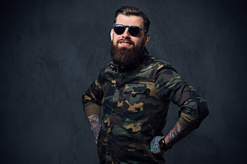 Portrait of bearded tattooed hipster male dressed in a military 