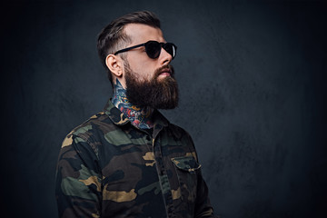 Portrait of bearded tattooed hipster male dressed in a military 