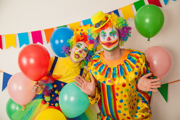 Fototapeta na wymiar Two cheerful clowns. Birthday for children. Bright clown and clowness.