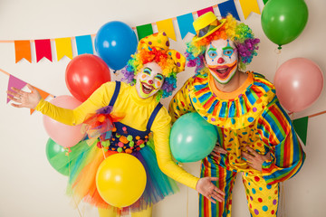 Two cheerful clowns. Birthday for children. Bright clown and clowness.