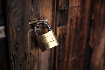 Old dark brown wooden door with padlock.
