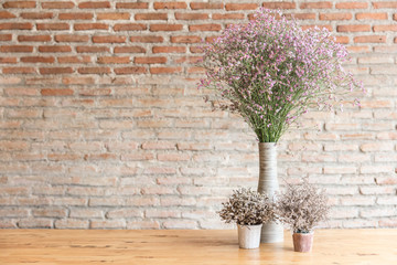 dried flower on wood table with brick wall background space for text vintage decoration