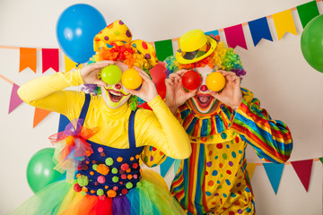 Two cheerful clowns. Birthday for children. Bright clown and clowness.