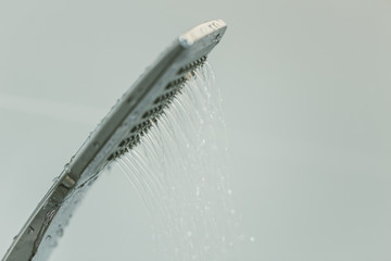 Low water pressure problem closeup at shower head in white bathroom