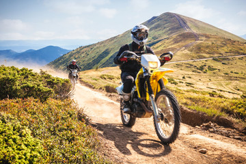 Enduro bikers crossing road in Carpathian mountains. © Dmytro Panchenko