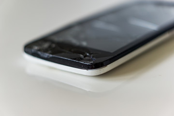 Close up of a broken smartphone on a white background.