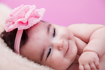 Cute, pretty, happy, chubby baby girl portrait with a big naughty smile. Naked or nude on fluffy...