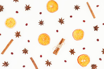 Pattern of cinnamon, anise and dried oranges isolated on white background. Flat lay, top view. Christmas or New Year concept