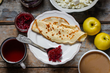 pancakes with jam from rose petals and other sweet additives on the wood surface
