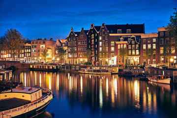 Fototapeta na wymiar Evening town Amsterdam in Netherlands on bank river canal Amstel