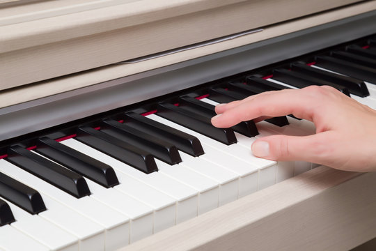Woman's hand playing a piano. Close up. Classical music concept.