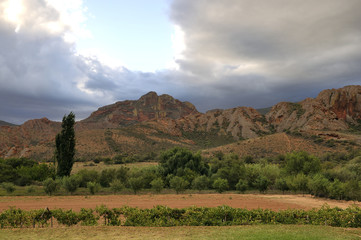 Ranch Overlooking a Mountain Range Under Cloudy Skies