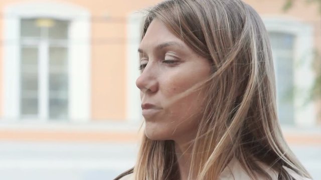 closeup portrait of deep in thought female face looking to the side. female face looking to the side when the wind waves her fair hair