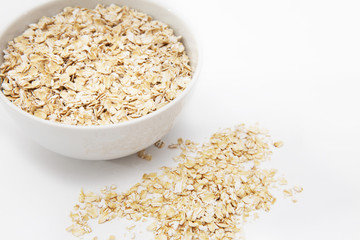 oat flakes in a white bowl on a white background